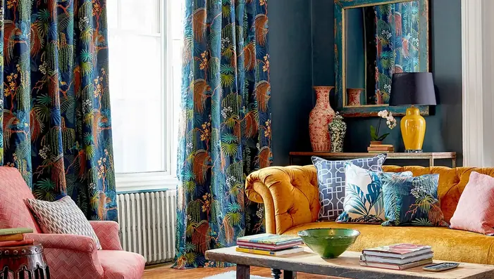 Designer cushions in a richly layered room with embroidered botanical fabrics