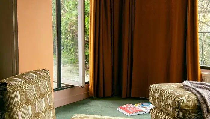 Full-length plain velvet curtains in a warm ochre interior