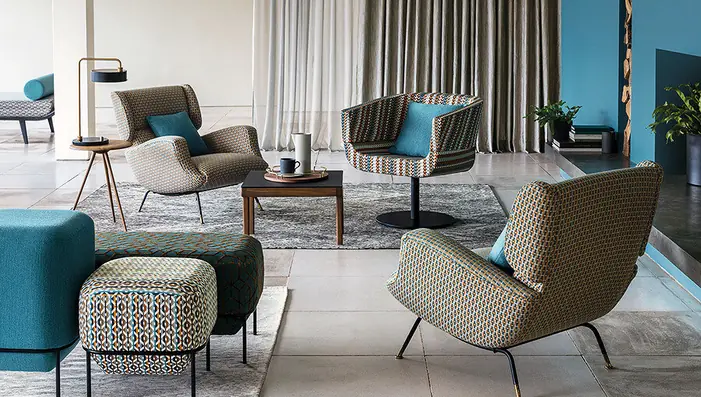 Contemporary contract interior with patterned Trevira upholstery fabrics and full-length curtains