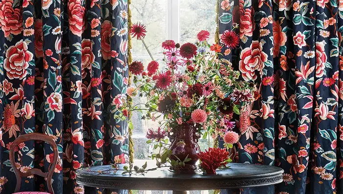 Richly coloured floral fabric curtains framing a window