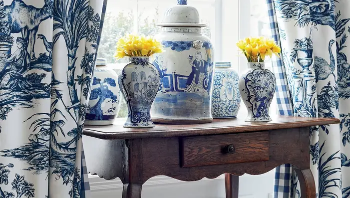 Blue Toile de Jouy curtains with coordinating check fabric in a bright, elegant interior.