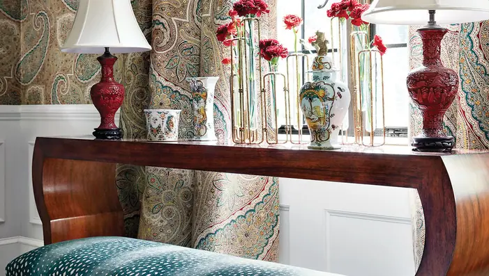 Traditional interior with full-length paisley curtains and an upholstered benc