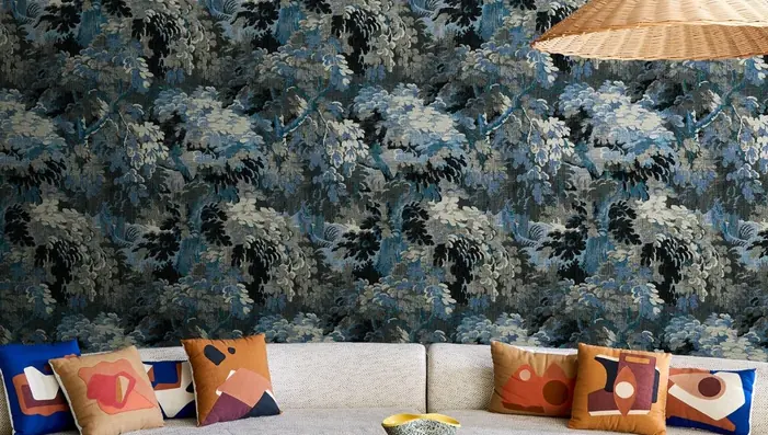 Blue Wallpaper with floral pattern behind a modern curved sofa in elegant interior setting