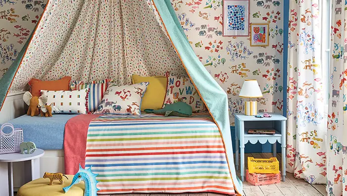 Colourful children's bedroom with patterned curtains, bedding and a fabric canopy