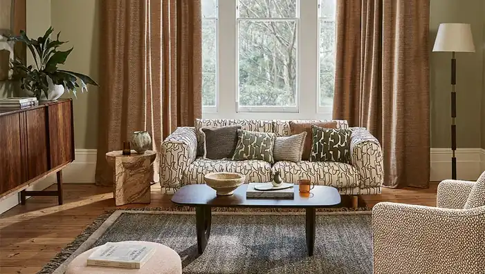 Villa Nova patterned upholstery and cushions with curtains in a warm neutral living room