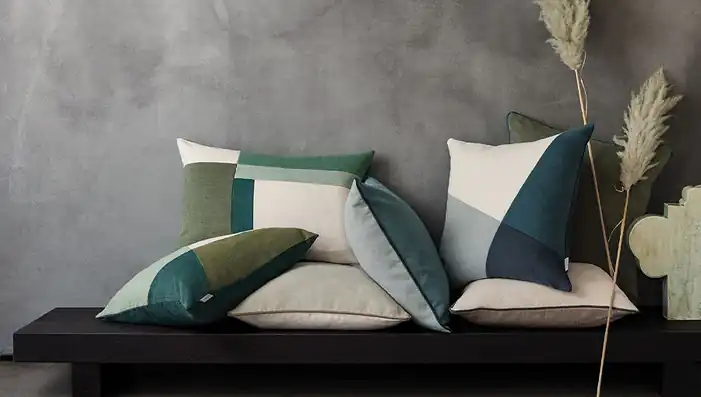 Plain and geometric patchwork Romo Linara cushions in green, teal and neutral shades