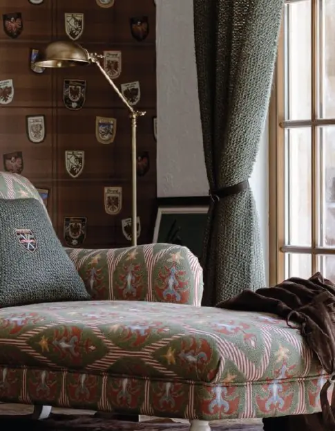 Heritage-style room featuring a chaise lounge upholstered in Der Tannenbaum fabric by MINDTHEGAP with shield motif wall covering