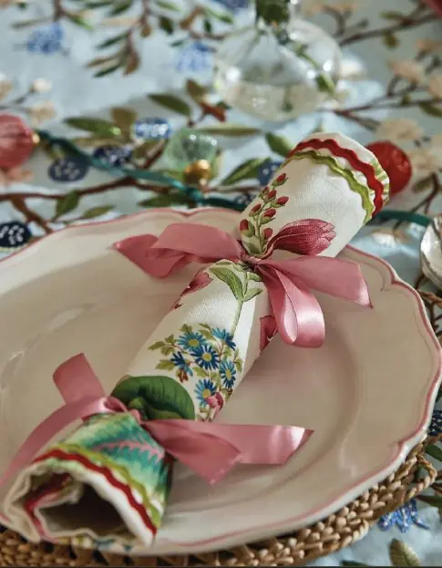 Handmade fabric crackers wrapped in colourful Sanderson floral fabric displayed on a decorative table setting with ribbon