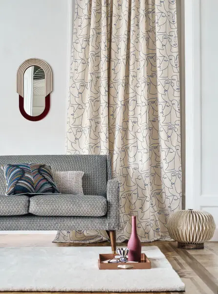 Abstract face pattern cream curtains in a contemporary living room.