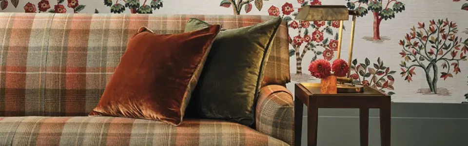 Living room with checked upholstery and velvet cushions paired with Nina Campbell fabric and wallpaper inspired by a Ralph Lauren aesthetic
