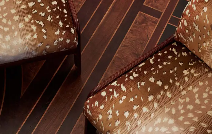 Velours Faon deer-inspired animal print velvet fabric by Nobilis on dining chairs