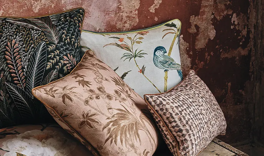 Pluma bird print fabric by Romo on a sofa, with stylised birds and botanicals creating a dramatic upholstery look