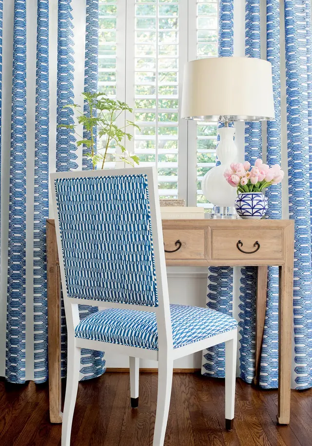 Blue embroidered geometric curtain fabric with coordinating upholstered chair