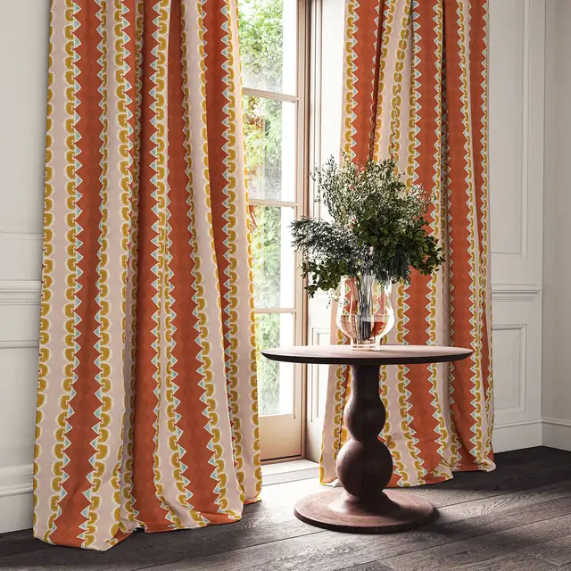 Bold warm striped linen curtains framing a bed