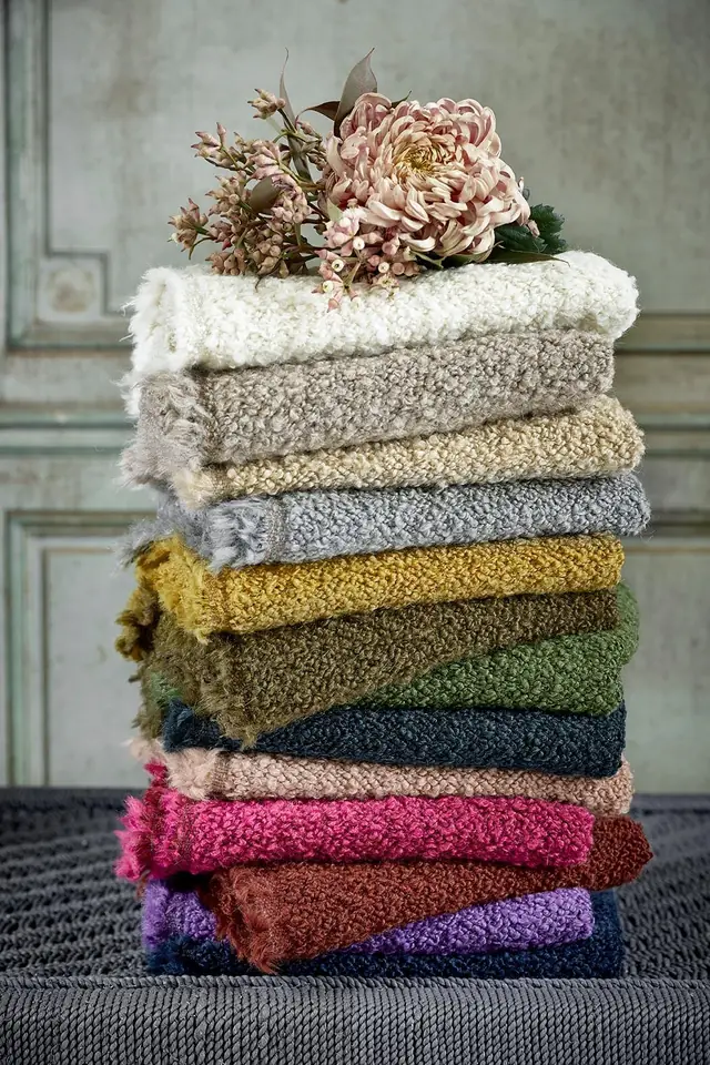 Stack of bouclé fabric samples in neutral and colourful shades