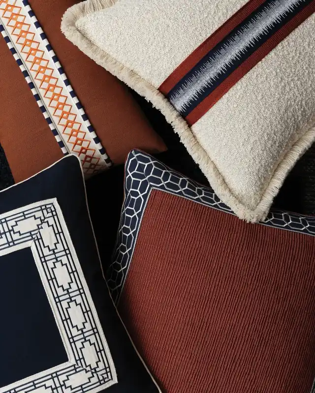 Navy, rust and cream cushions decorated with geometric bands and borders