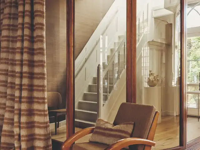 Brown checked curtains beside a timber chair and glazed partition