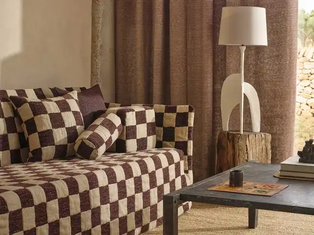 Large brown and cream checks on seating beside plain brown curtains