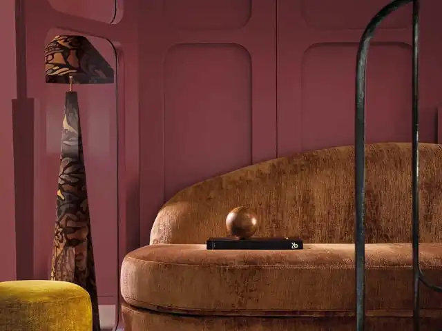 Rich brown upholstered sofa against a deep burgundy wall