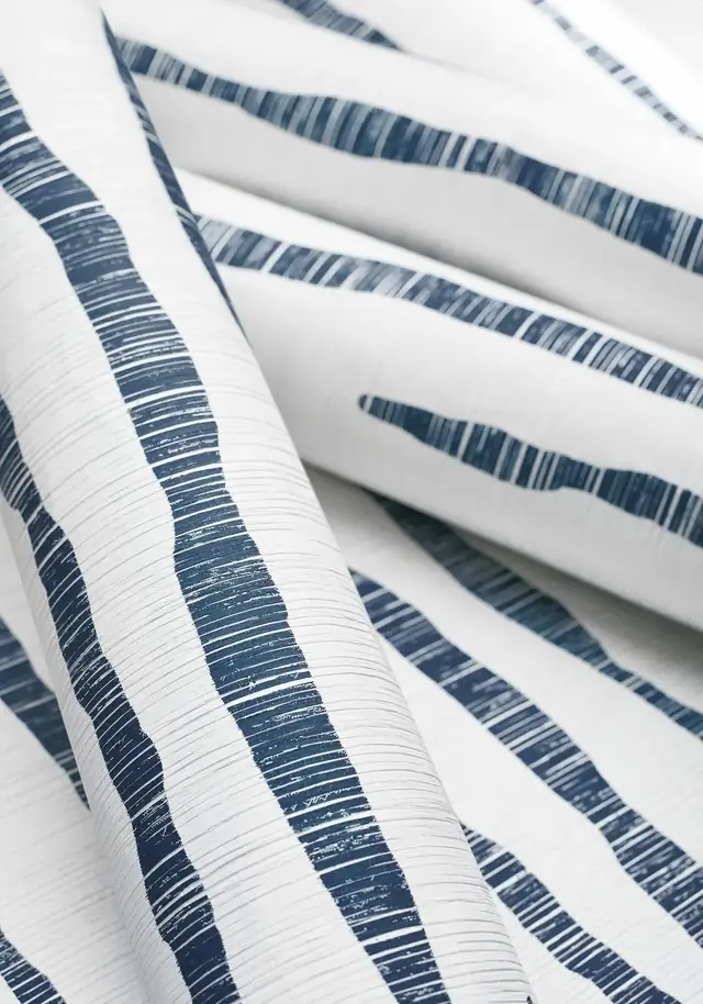 Blue and white zebra stripe wallpaper rolls showing the printed texture and finish