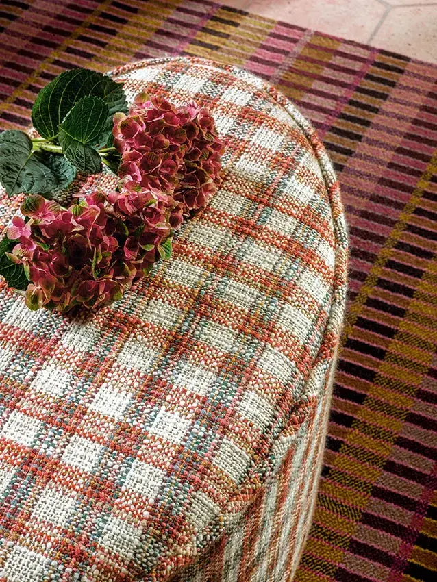 Multicoloured checked woven upholstery fabric on a rounded ottoman