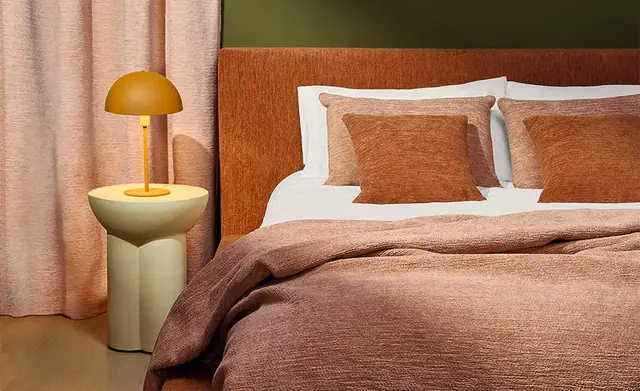 Soft chenille curtains, upholstered headboard and coordinating cushions in warm pink and rust