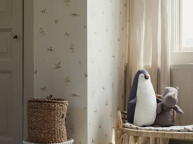 Soft woodland nursery wallpaper beside a window and children’s toys
