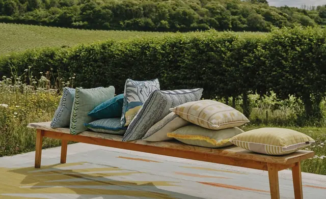 Christopher Farr Cloth patterned and textured cushions arranged outdoors