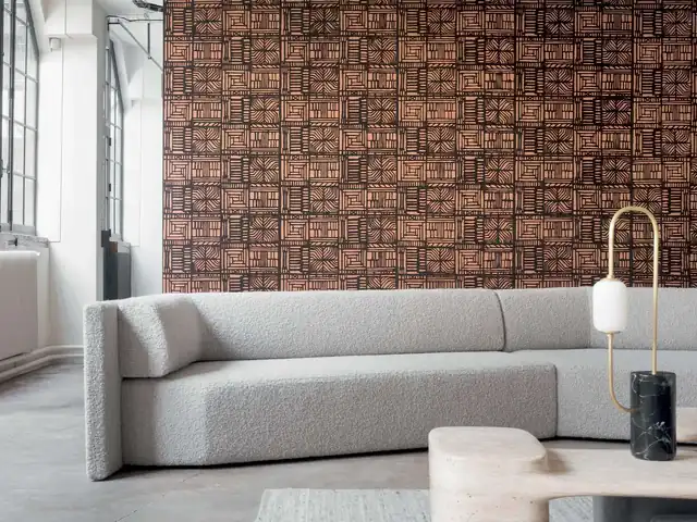Copper and black contemporary paper wallcovering above a curved white sofa