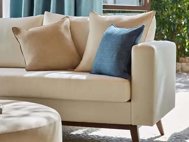 Cream upholstered sofa with neutral and blue cushions