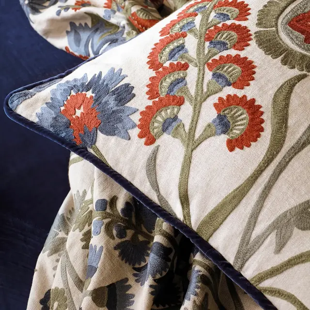Close-up of traditional floral crewel embroidery on a woven fabric ground