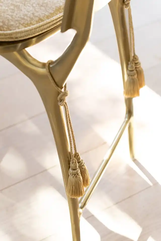 Gold decorative tassels tied to a gold chair frame