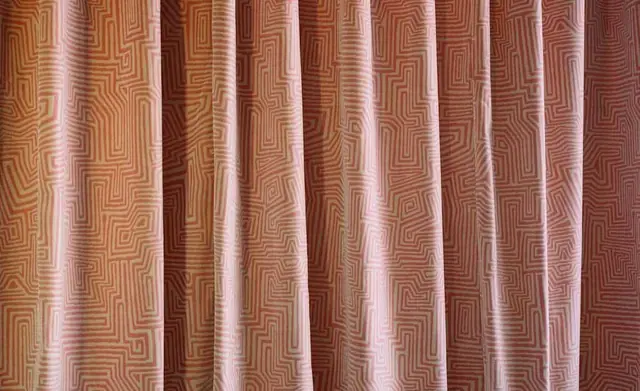 Soft pink Dedar patterned fabric hanging as full curtains