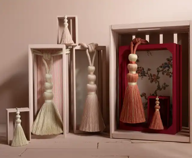 Cream, blush and coral tassel tiebacks displayed with coordinating fabric swatches