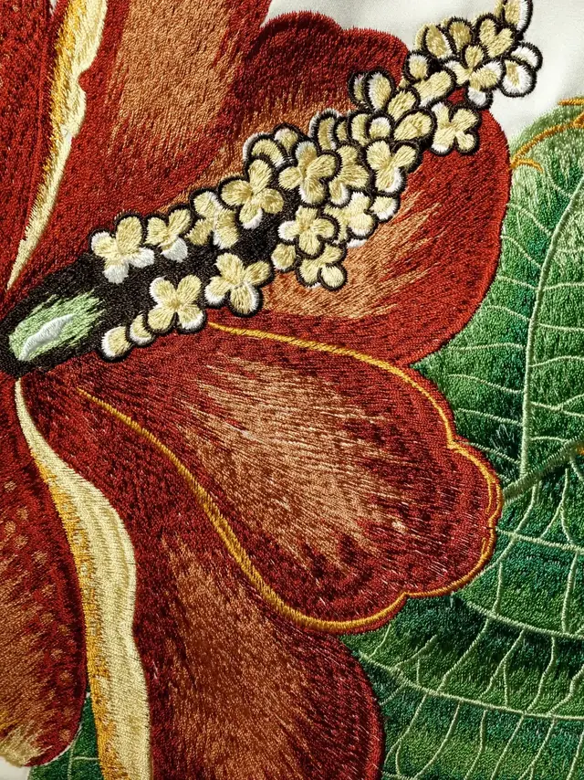 Close-up of richly coloured floral embroidery showing raised stitched detail