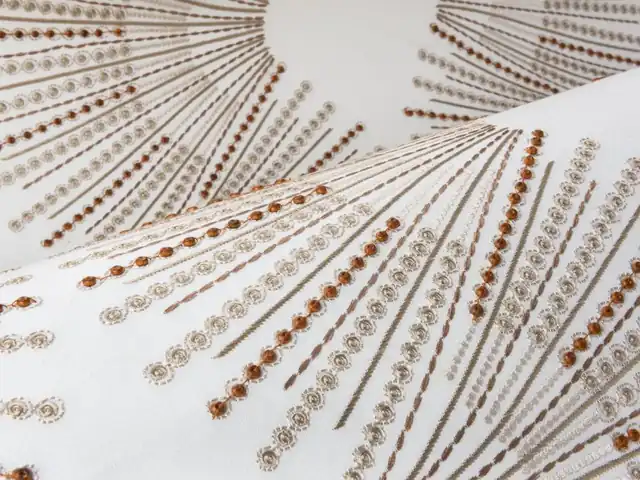 Close-up of radiating embroidered lines showing raised thread and bead-like detail