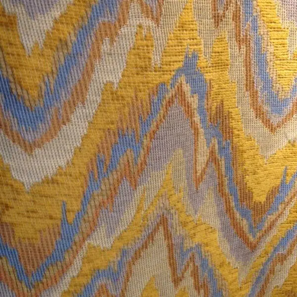 Flame stitch fabric with elongated jagged chevrons resembling rising flames