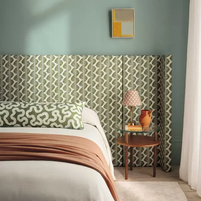 Contemporary full-width upholstered headboard in green patterned fabric