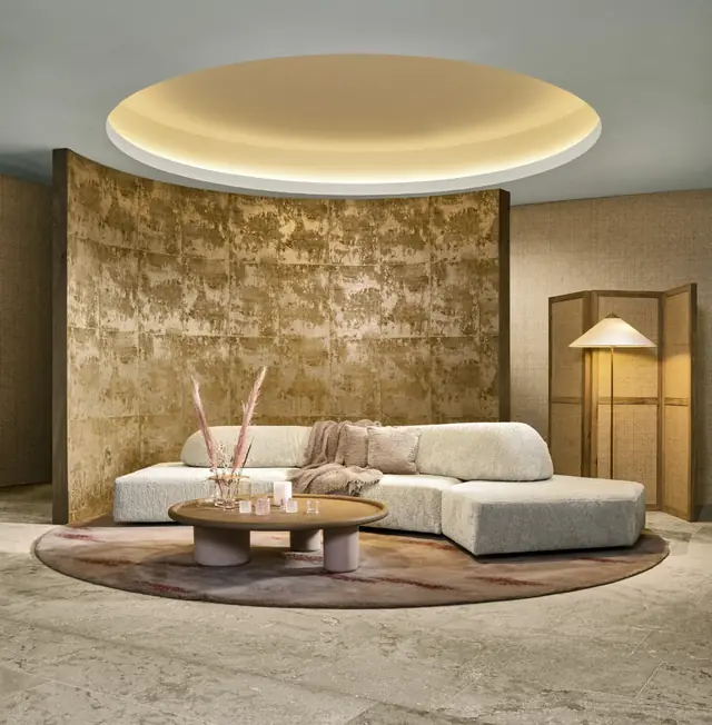 Gold metallic wallpaper with a softly aged patinated finish in a contemporary living room