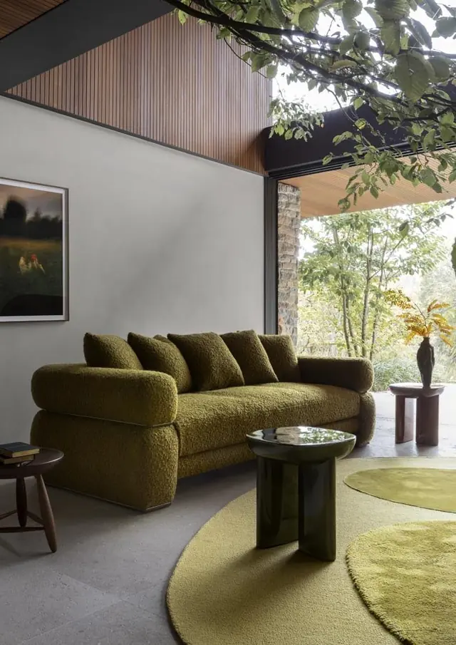 Deep green bouclé sofa in a contemporary living room