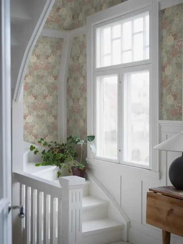 Floral wallpaper continuing through a hall staircase and landing