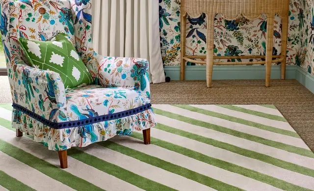 Harlequin patterned fabric, wallpaper and rug in a colourful interior