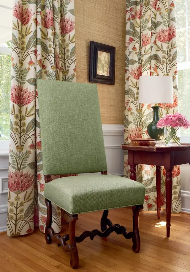 Large-scale stylised floral curtain fabric in red, green and soft neutral tones