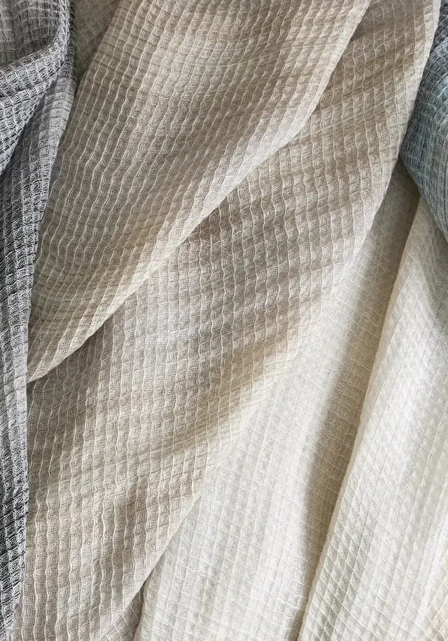 Full-length light-filtering voile curtains arranged across a glazed window