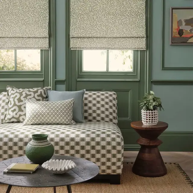 Coordinating Roman blinds, upholstery and cushions in a green interior