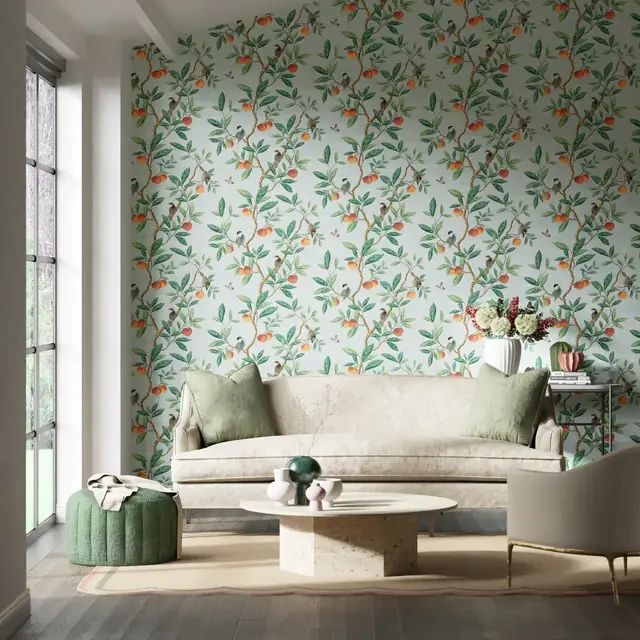 Contemporary pale green wallpaper with fine branches, leaves and orange birds in a living room