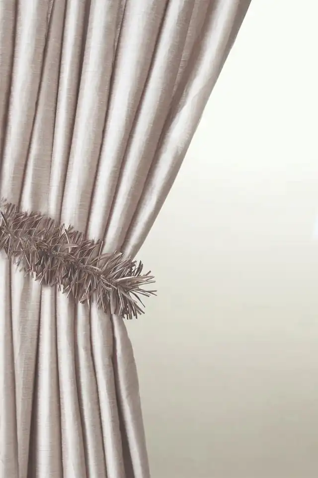 Sculptural textured tieback around a pale curtain