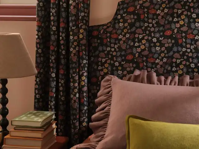 Small multicoloured floral fabric used on curtains and a headboard beside plain cushions