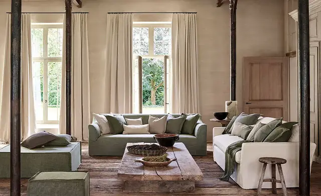 Natural linen curtains dressing tall windows in a relaxed neutral living room
