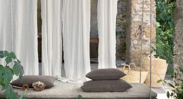 Natural white linen sheer curtains softly filtering daylight across a glazed wall